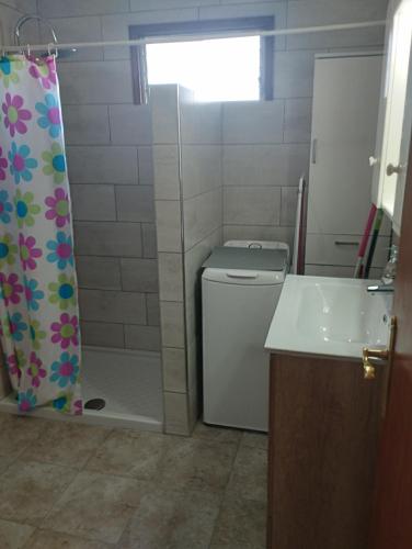 uma casa de banho com um WC e uma cortina de chuveiro em Vivienda vacacional em Mocanal