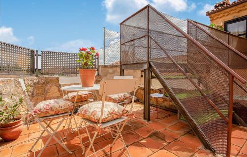 a patio with a table and chairs and a bird cage at 2 Bedroom Nice Home In Imon in Imón