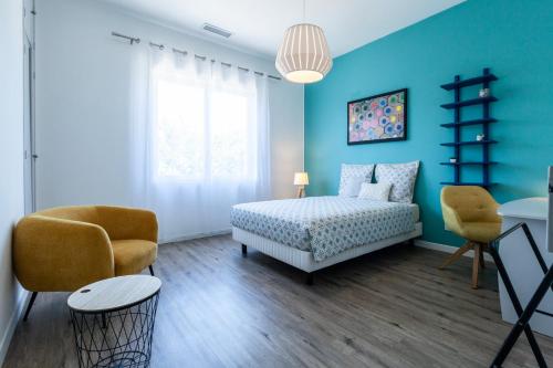 une chambre avec un lit et deux chaises dans l'établissement Appartement convivial proche centre - Terrasse & Parking privé gratuit, à Avignon