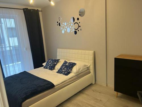 1 dormitorio con 1 cama y reloj en la pared en Apartament Korczak Park, en Kalisz