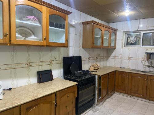 a kitchen with wooden cabinets and a stove top oven at 2 Bedroom Apartment F11 Islamabad - Askin in Islamabad