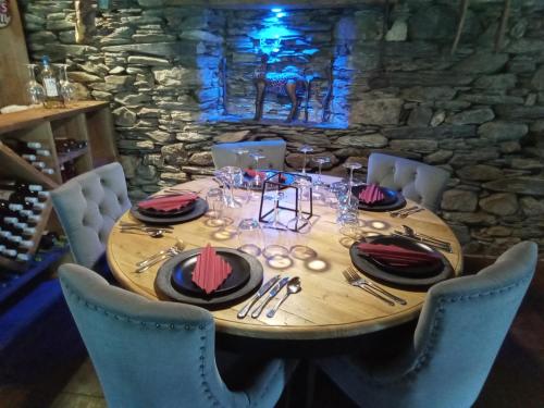 a wooden table with plates and glasses on it at L' Auberge du château in Génos
