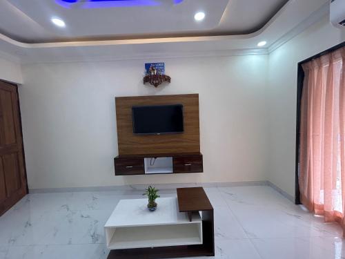 a living room with a tv on a wall at HOLIDAY LUXURY APARTMENT in Arpora