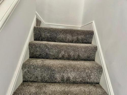 a stair case with a carpeted staircase in a house at Executive 3 bedroom Port Talbot Town Centre Margam Sleeps 7 in Taibach