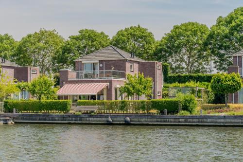 a house on the side of a body of water at Nautic Rentals - Marinapark Oude-Tonge in Oude-Tonge