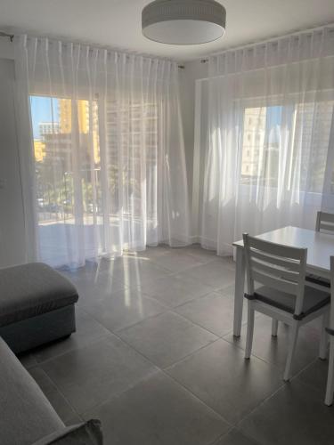 a living room with a table and a chair at Apartamentos La Gaviota in Roquetas de Mar