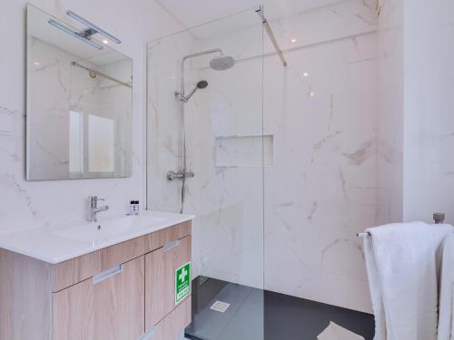 een badkamer met een douche, een wastafel en een spiegel bij AL - Atlântida Penthouse in Quarteira