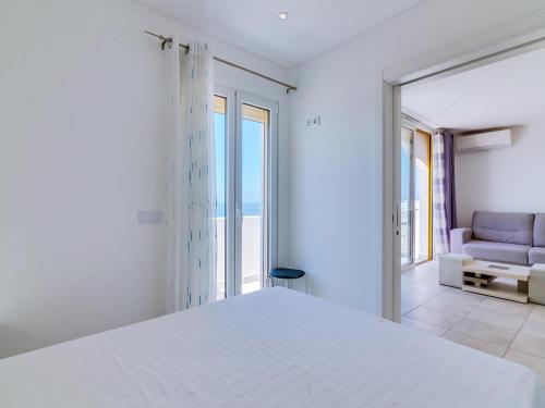 a white bedroom with a bed and a couch at AL - Atlântida Penthouse in Quarteira