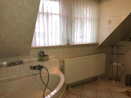 a bathroom with a bath tub and a window at Tannhäuser Hörselhäuschen in Wutha-Farnroda