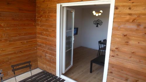 eine offene Tür zu einem Zimmer mit Holzwänden in der Unterkunft Logements 18moliere fr Futuroscope Poitiers in Chasseneuil-du-Poitou