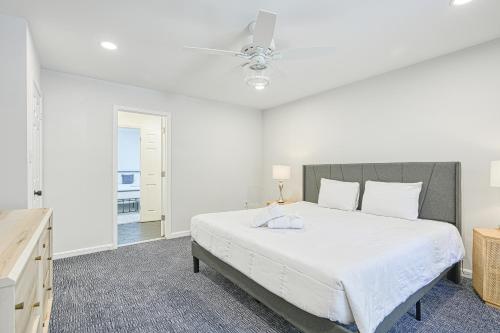 a bedroom with a large white bed with a ceiling fan at Lake it to the Limit in Bumpass