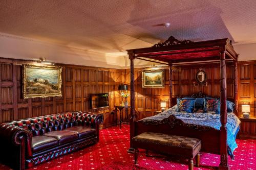 een slaapkamer met een bed en een bank bij Finest Retreats - Apley Hall in Bridgnorth