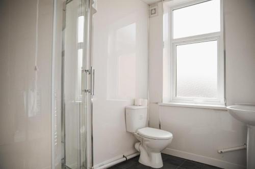 bagno bianco con servizi igienici e lavandino di Luxury City Rooms in Leicester a Leicester