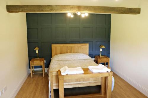 a bedroom with a bed with two tables and two lamps at The Lodge - 2 acres of garden with hot tub and fire pit and BBQ in East Harling