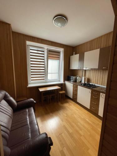a kitchen with a couch and a table in a room at OAK apartment in Vilnius