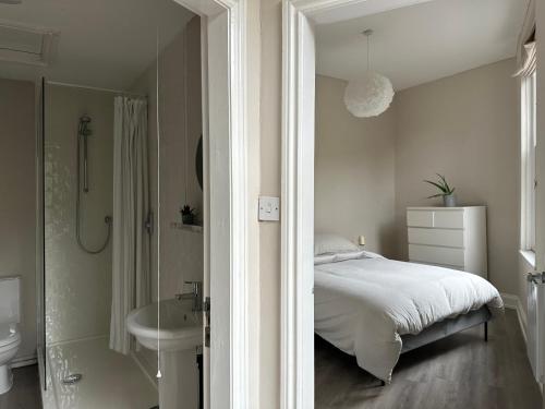 a bedroom with a bed and a sink and a shower at Strawberry Dale Apartment in Harrogate