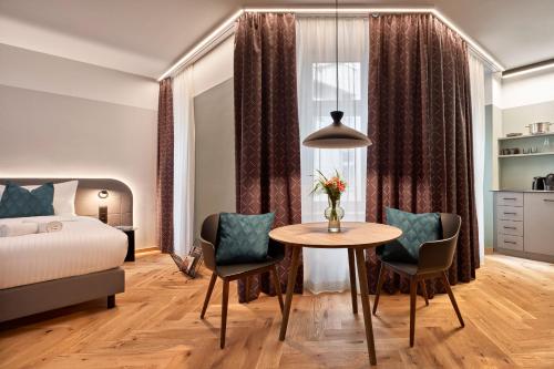 1 dormitorio con 1 cama, mesa y sillas en URBANAUTS STUDIOS Fillgrader, en Viena