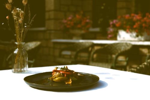 Hostellerie Du Lys في Lamorlaye: صحن أسود من الطعام على طاولة
