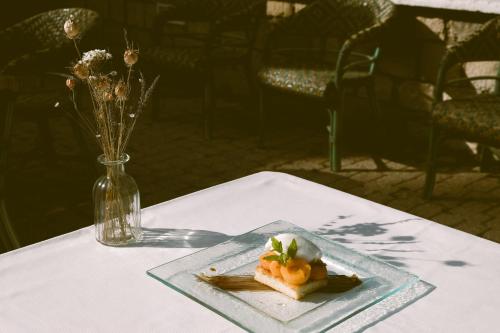 Hostellerie Du Lys في Lamorlaye: طبق من الطعام على طاولة مع مزهرية