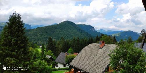 - une vue sur une maison avec des montagnes en arrière-plan dans l'établissement Holiday House Jezerka, à Bohinj