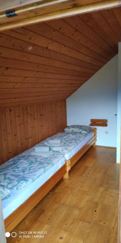 Ce lit se trouve dans un dortoir doté d'un plafond en bois. dans l'établissement Holiday House Jezerka, à Bohinj