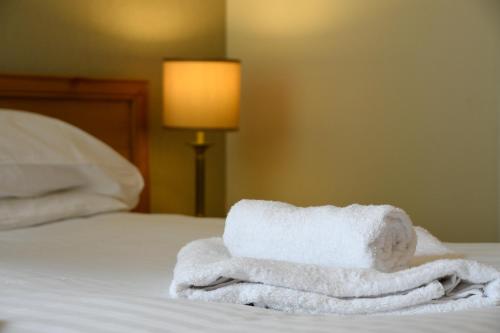 uma pilha de toalhas sentadas em cima de uma cama em Strathnaver em Oban