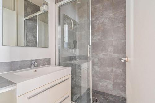 une salle de bain avec un lavabo blanc et une douche dans l'établissement Warm & Welcoming Flat - Family's Ideal - Marais, à Paris