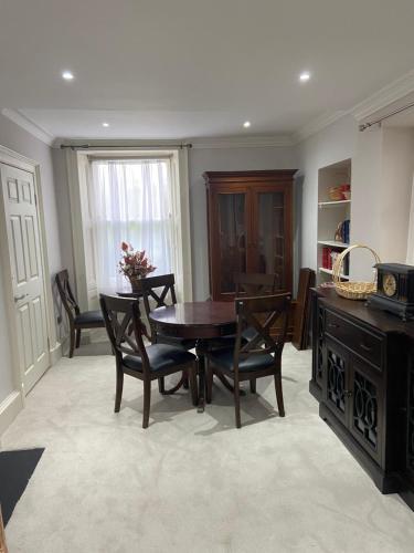 Merchiston Residence في إدنبرة: غرفة طعام مع طاولة وكراسي