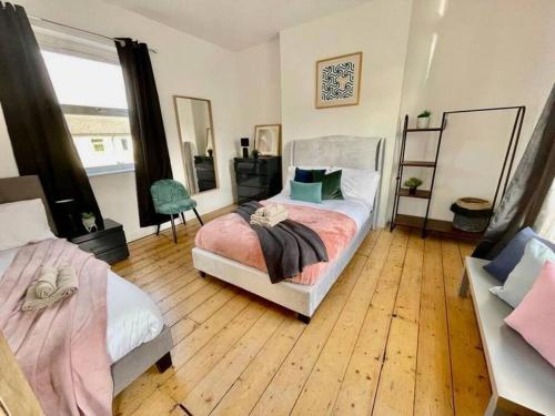 a bedroom with two beds and a wooden floor at Brewery Loft in Newport