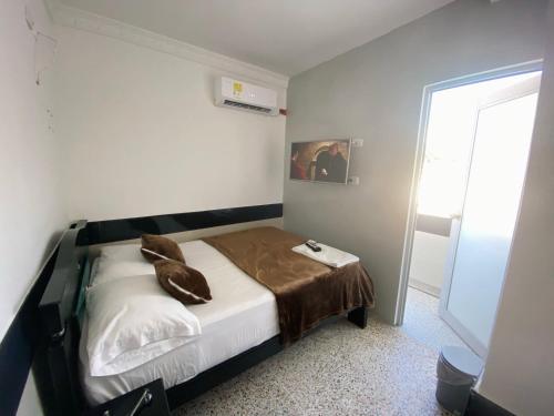 - une chambre avec un lit et une couverture brune dans l'établissement HOTEL IMPERIAL LA QUINTA, à Aguachica