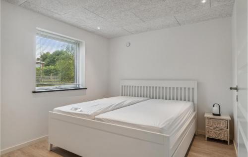 een witte slaapkamer met een bed en een raam bij Gorgeous Home In Jgerspris With Kitchen in Jægerspris