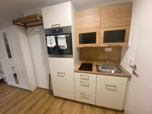 a small kitchen with a sink and a refrigerator at Auszeit Salzkammergut Appartements in Bad Ischl