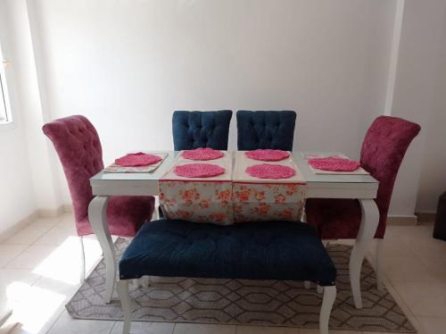 a table with two chairs and a table with pink plates on it at 2 bedrooms private townhouse in Zayed in Sheikh Zayed