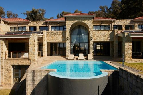 una vista exterior de una casa con piscina en Mseleku Villa, en Harrismith