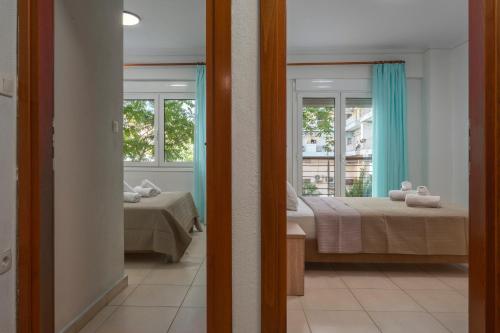 a room with a bed and a window and a mirror at Kosmos Sevice Apartment Family 4A in Thessaloniki