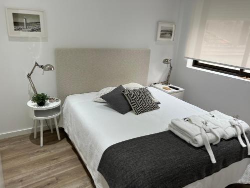 a bedroom with a bed and a table with a lamp at Foz Relógio Apartment in Figueira da Foz