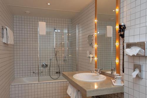 a bathroom with a sink and a shower at Hotel Theresientor in Straubing