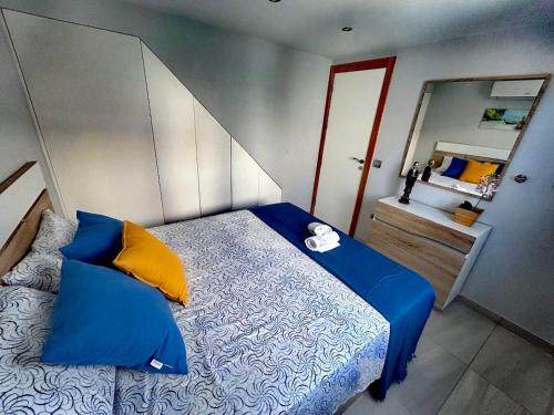 una camera da letto con un letto con cuscini blu e gialli di Chalet Privato con Jacuzzi New a Maspalomas