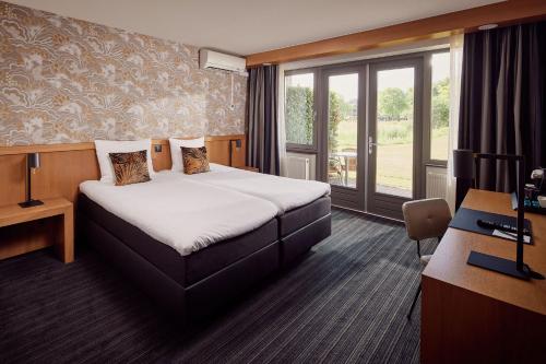 a hotel room with a bed and a desk at Van der Valk Drachten in Drachten