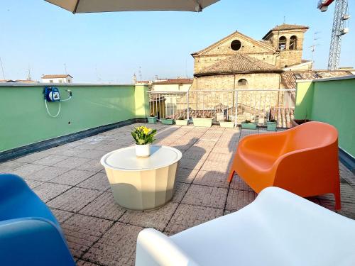 a patio with chairs and a table and a building at TINTORIA in Parma