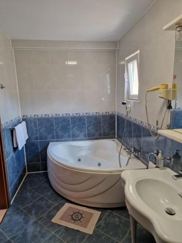 łazienka z dużą wanną i umywalką w obiekcie Vila Sara w mieście Chişoda