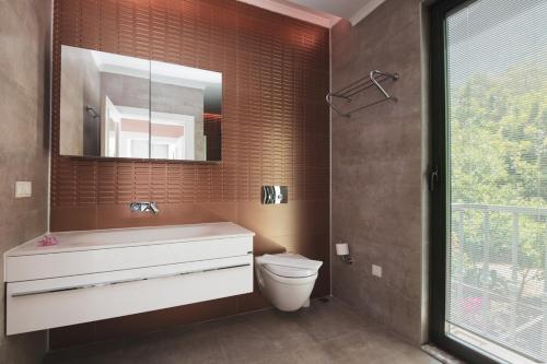 y baño con lavabo, aseo y espejo. en KIDRAK PREMIUM VILLAS, en Fethiye