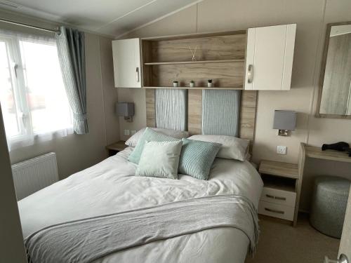 a bedroom with a large bed with two pillows at Fairview Caravan Hire in Lossiemouth