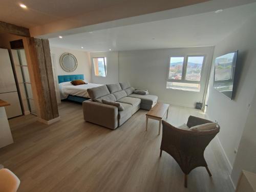 een woonkamer met een bank en een bed bij Atractivo piso recién reformado in Santander