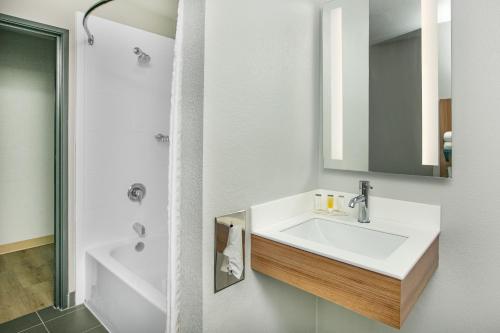 uma casa de banho branca com um lavatório e um espelho em Microtel Inn by Wyndham Beckley em Beckley