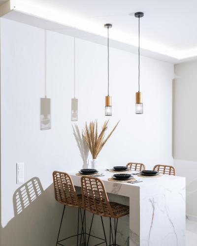 a white dining room with a table and chairs at Arbona Apartment II in Vóroi
