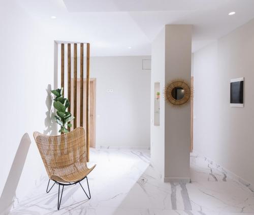 a rattan chair in a white room with a plant at Arbona Apartment II in Vóroi