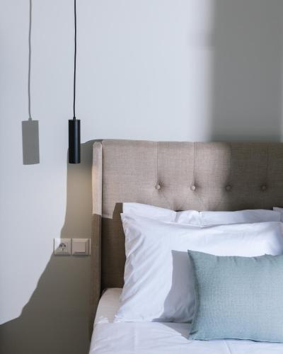 a bed with white sheets and blue pillows at Arbona Apartment II in Vóroi