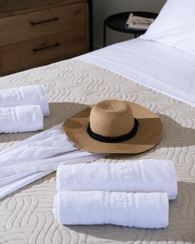 a straw hat sitting on top of a bed with towels at Arbona Apartment II in Vóroi
