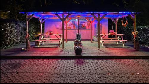 un escenario con dos mesas y luces púrpuras en Romantischer Bauwagen im Grünen en Oberhausen